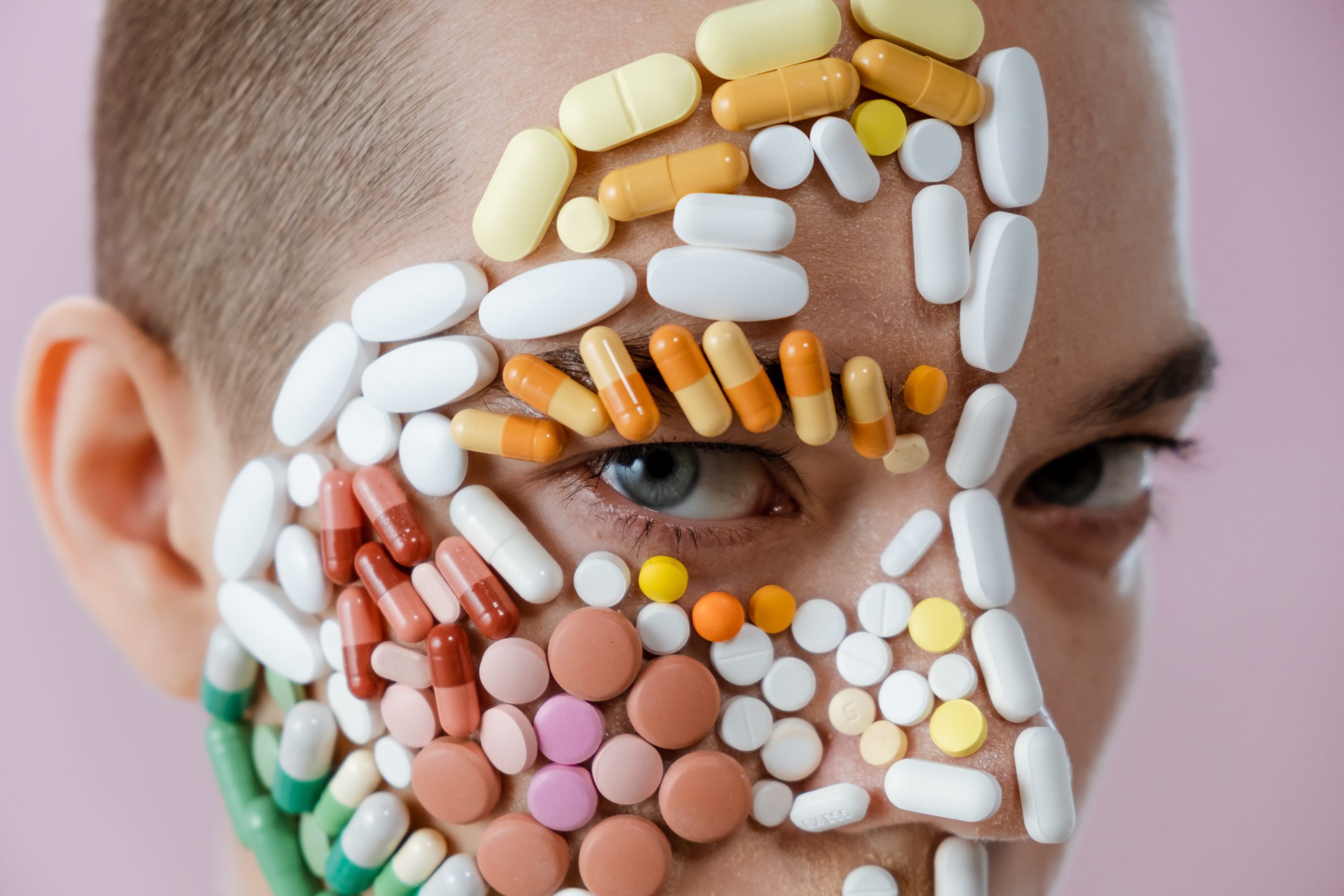 Une image du visage d'une femme couverte de différentes pilules - L'oncologie integrative